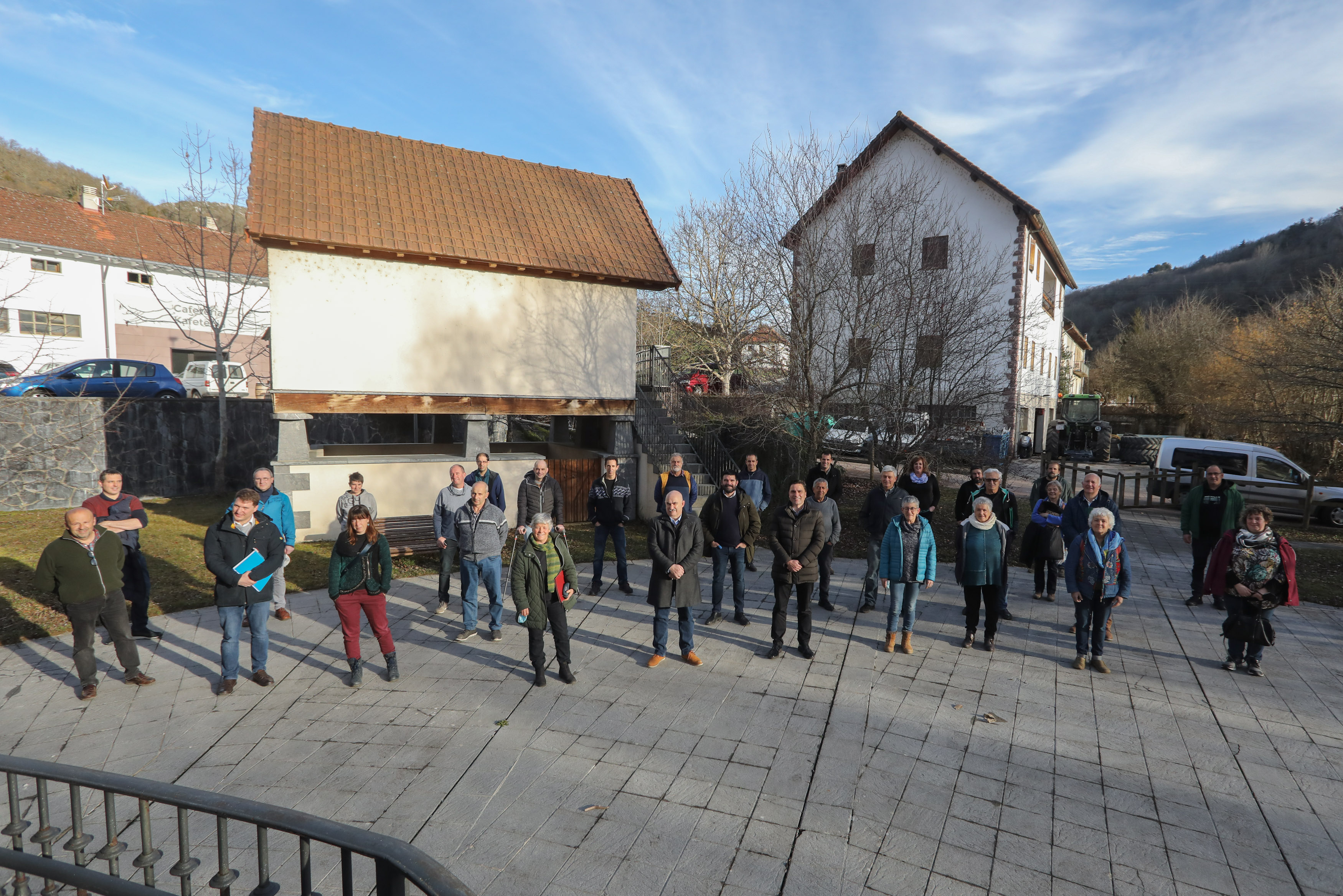 Fotografía de varias personas de pie en una plaza de un pueblo.