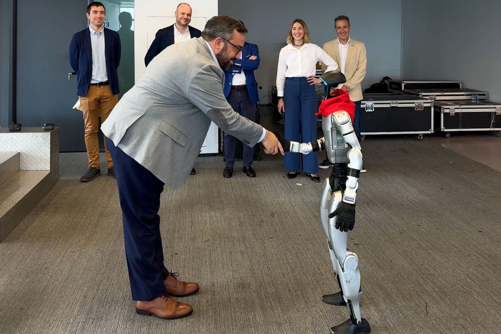 Un robot saludando con la mano a una persona