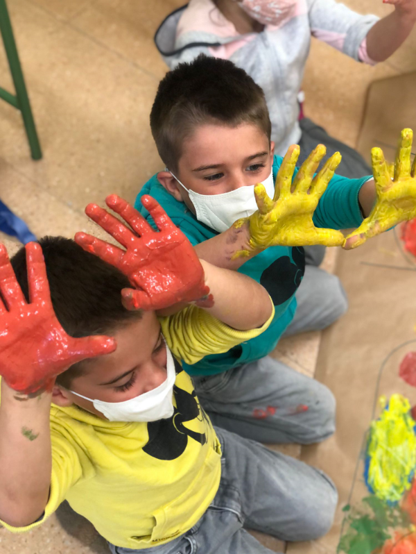 Fotografía de dos niños con las manos con pintura