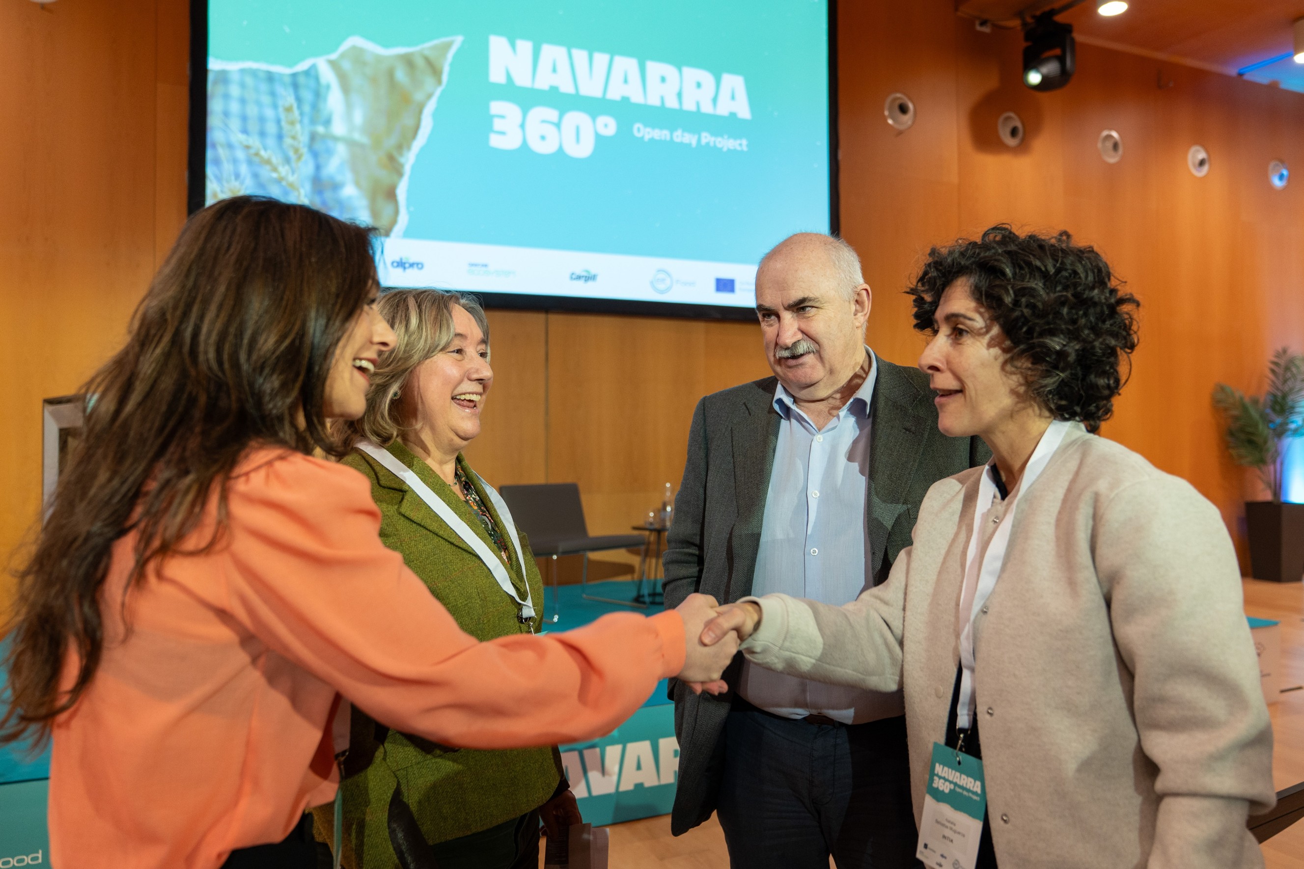Fotografía de 4 personas hablando y estrechando manos
