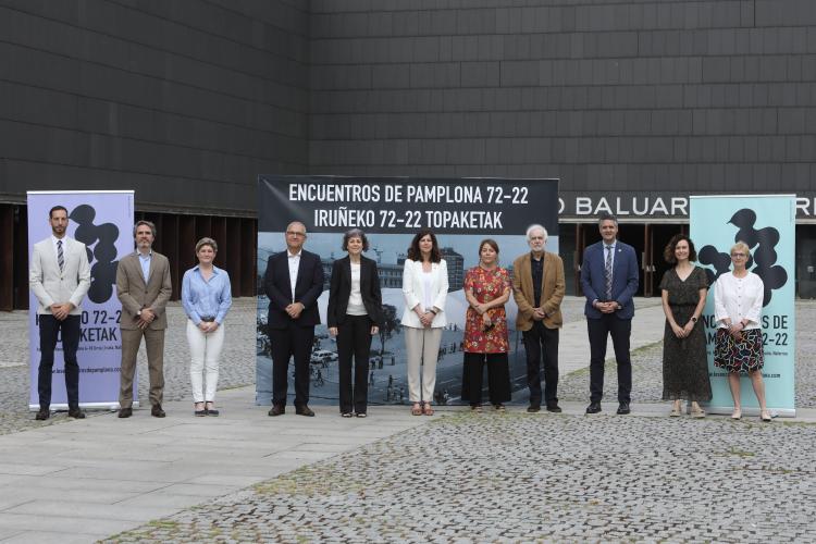 Fotografía de varias personas de pie delante de la fachada del edificio de Baluarte.