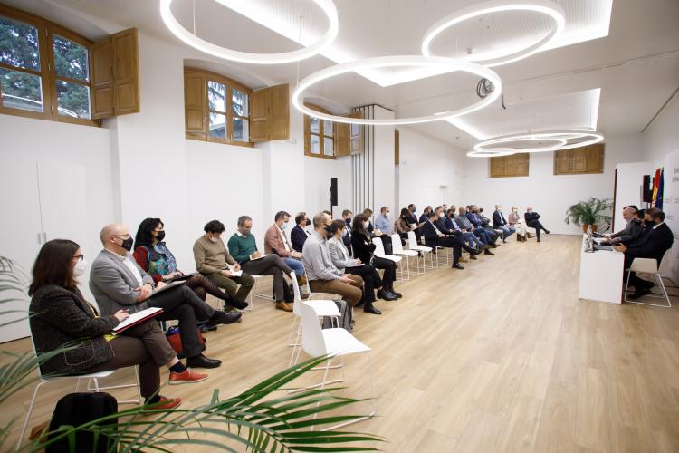 Fotografía interior donde aparecen varias personas sentadas durante la presentación del proyecto