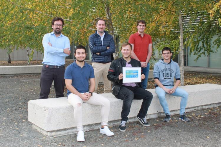 Fotografía de seis chicos sentados en un banco mostrando un diploma.