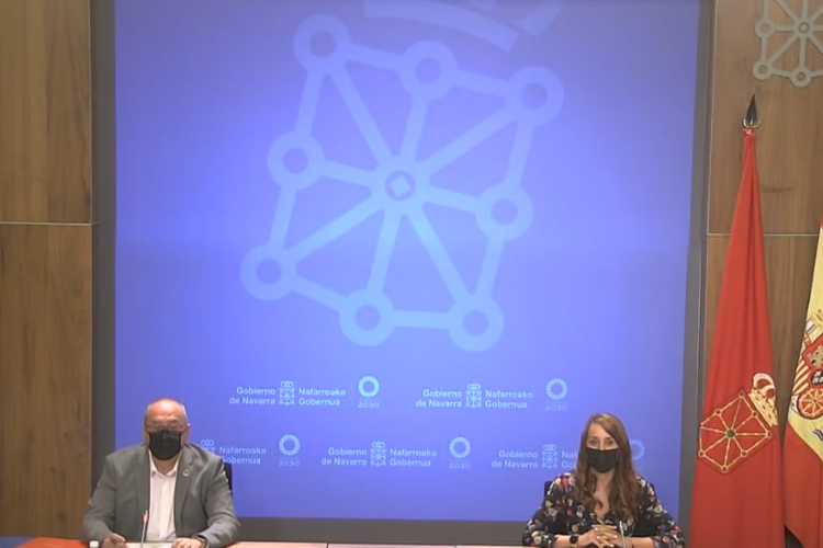Fotografía de dos personas sentadas en una rueda de prensa