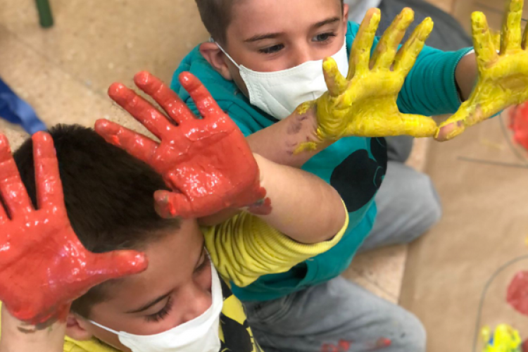 Fotografía de dos niños con las manos con pintura