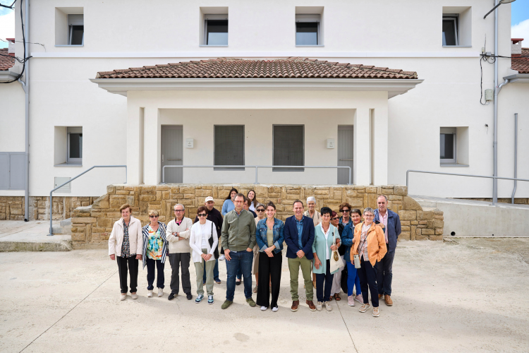 Fotografía de las personas participantes en la visita han posado frente a la fachada de edificio rehabilitado