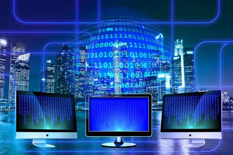 Fotografía de tres pantallas de ordenador en un fondo azul 