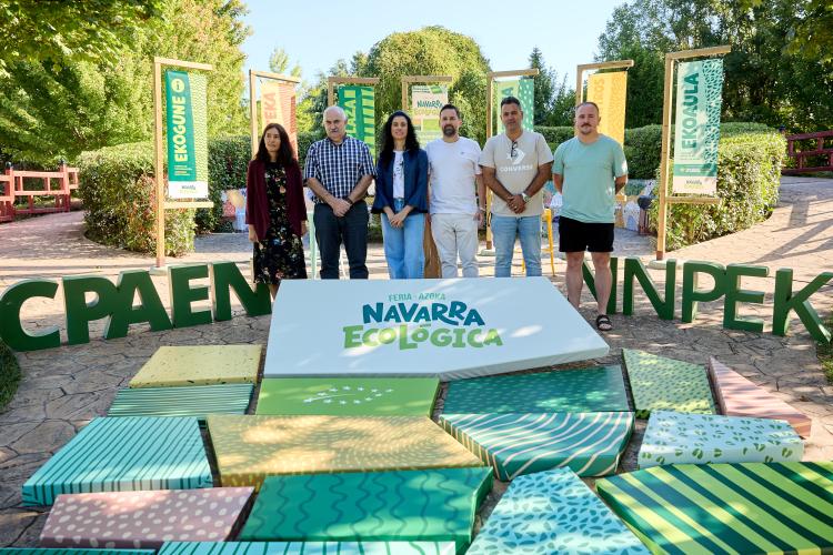 Varias personas posando al aire libre detrás del logo de la propuesta