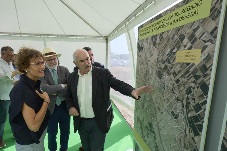 Dos personas mirando e interpretando un cartel con un mapa 