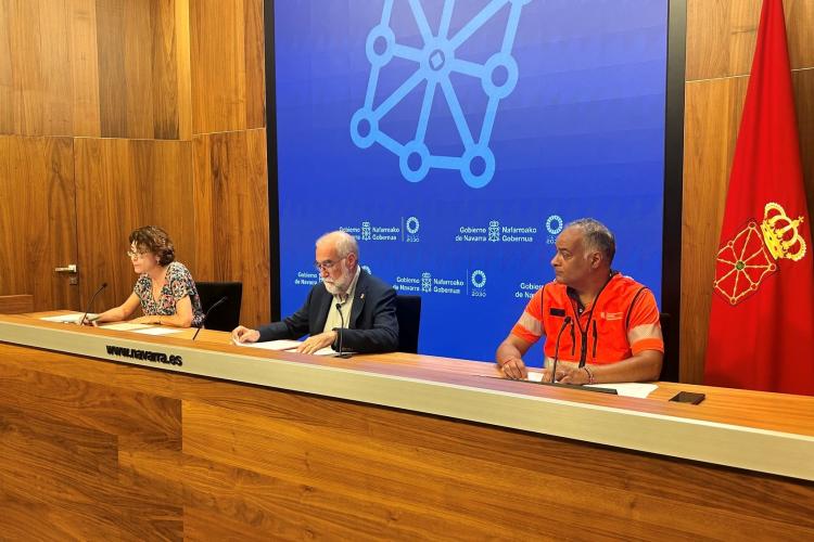 3 personas sentadas mientras se realiza una rueda de prensa