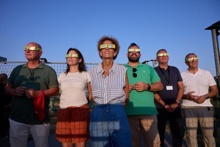 Varias personas observando el cielo con las gafas del eclipse puestas