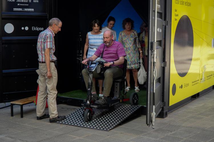 Una persona con discapacidad desciende de la cabina de simulación inmersiva de un eclipse total de Sol